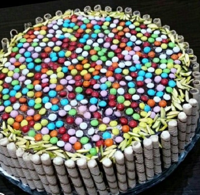 کیک تزیین شده با ویفر شوکورول و اسمارتیزهای رنگی
